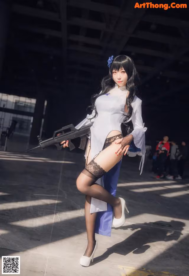 A woman in a white shirt and black stockings holding a gun.