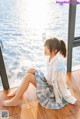 A woman sitting on the floor in front of a window.