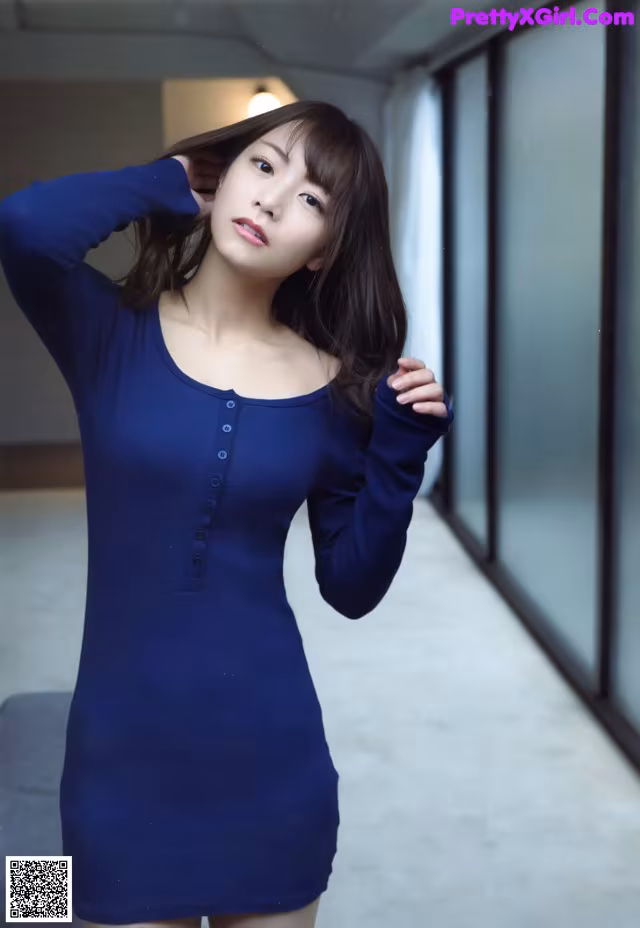 A woman in a blue dress posing for a picture.