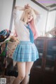 A woman with pink hair wearing a blue skirt and a white shirt.