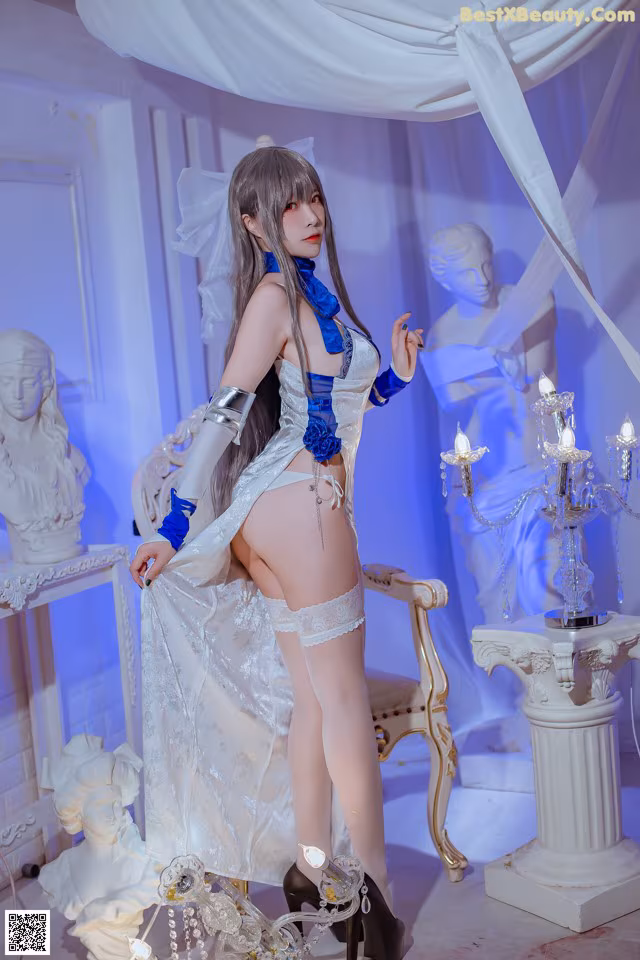 A woman in a white and blue lingerie posing for a picture.