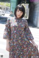 A woman in a floral dress is posing for a picture.