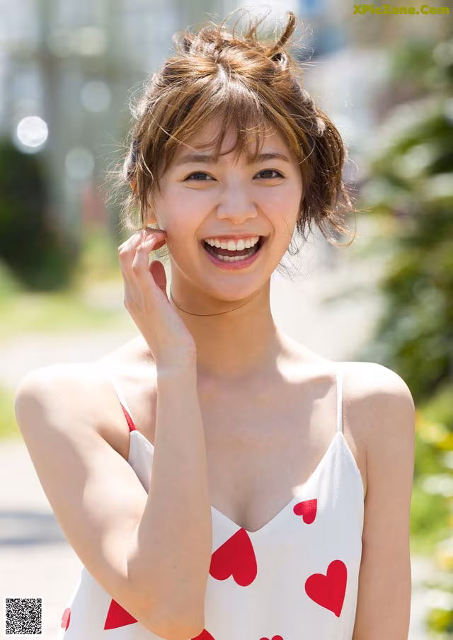 A woman in a white dress with red hearts on it.