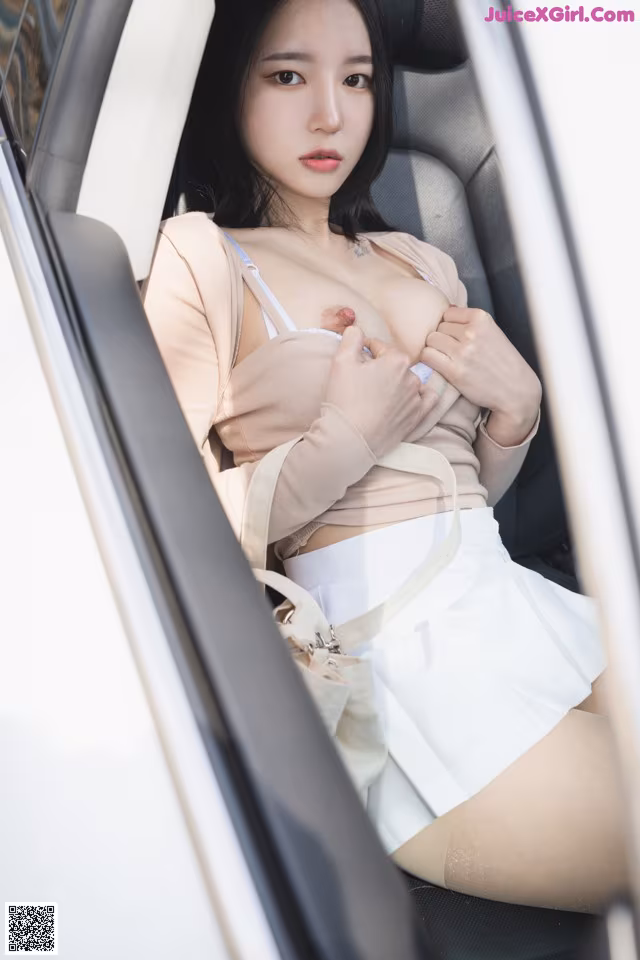 A woman sitting in the back seat of a car.