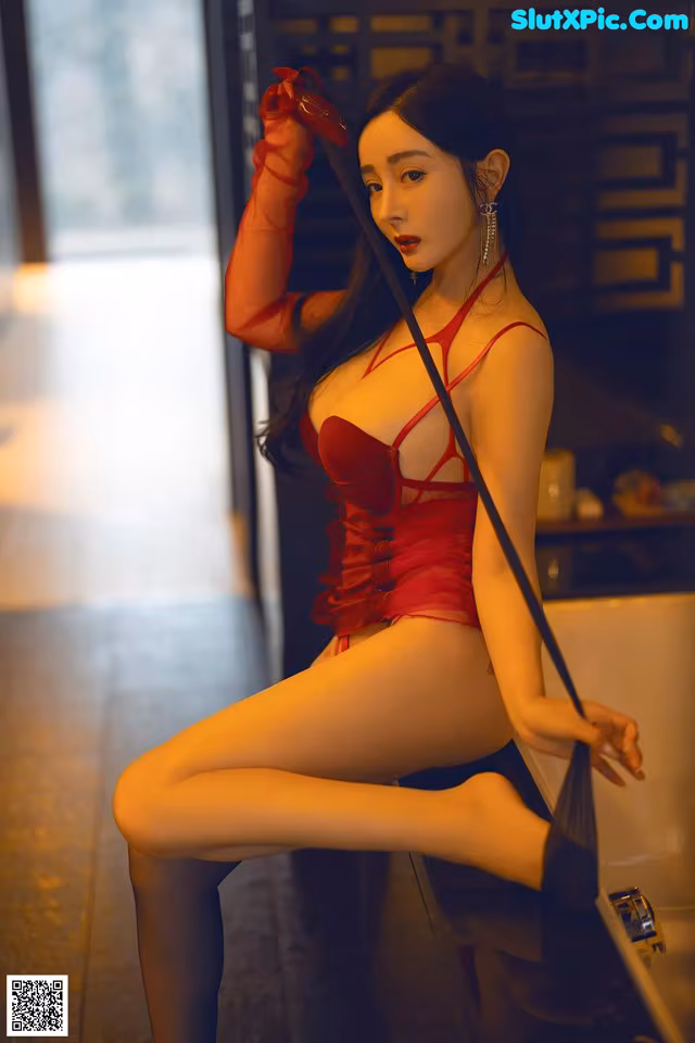 A woman in a red lingerie posing for the camera.