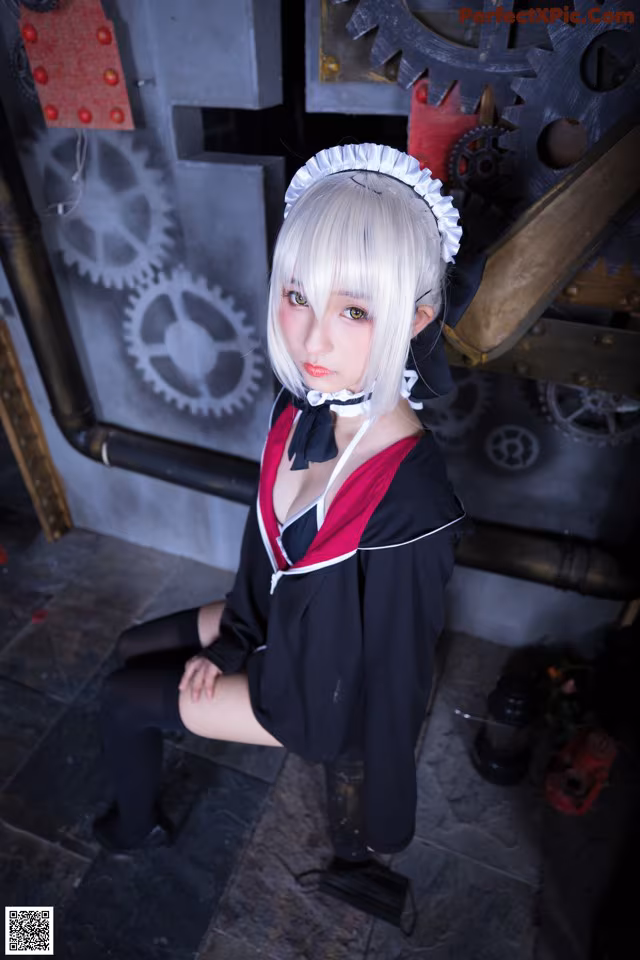 A woman in a maid outfit posing for a picture.