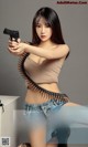 A woman holding a gun with a bullet belt around her waist.