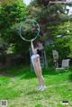 A woman in a white bathing suit holding a hula hoop.