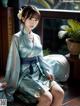 A woman in a blue kimono sitting on a wooden floor.