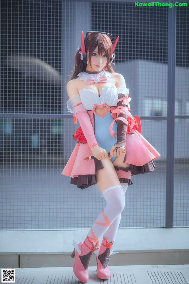 A woman in a pink and white outfit posing for a picture.