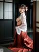 A woman in a red and white kimono posing for a picture.